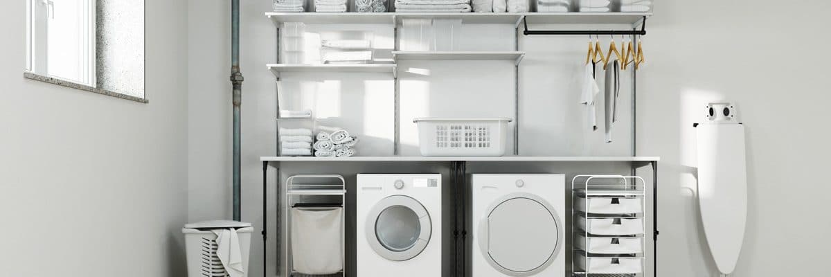 Une buanderie blanche avec lave-linge, sèche-linge et la table à repasser