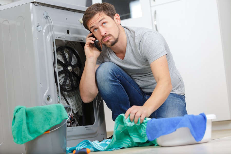 un homme gère une panne de sèche-linge 